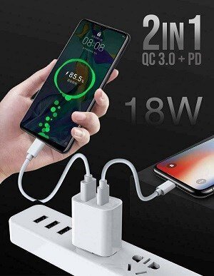 A hand holds a smartphone displaying its charging status. Phones are connected to a power strip via a dual-port wall charger labeled "Generic 20W SupRShield Dual PD & USB Type-C Fast Charging Wall Plug Charger Adapter - Store.