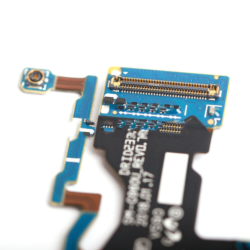 Close-up image of an electronic circuit board with various components, including connectors and metallic traces, featuring an OG Charging Port Flex Cable for Samsung Galaxy S9 (G960U), mounted on a blue and black substrate.