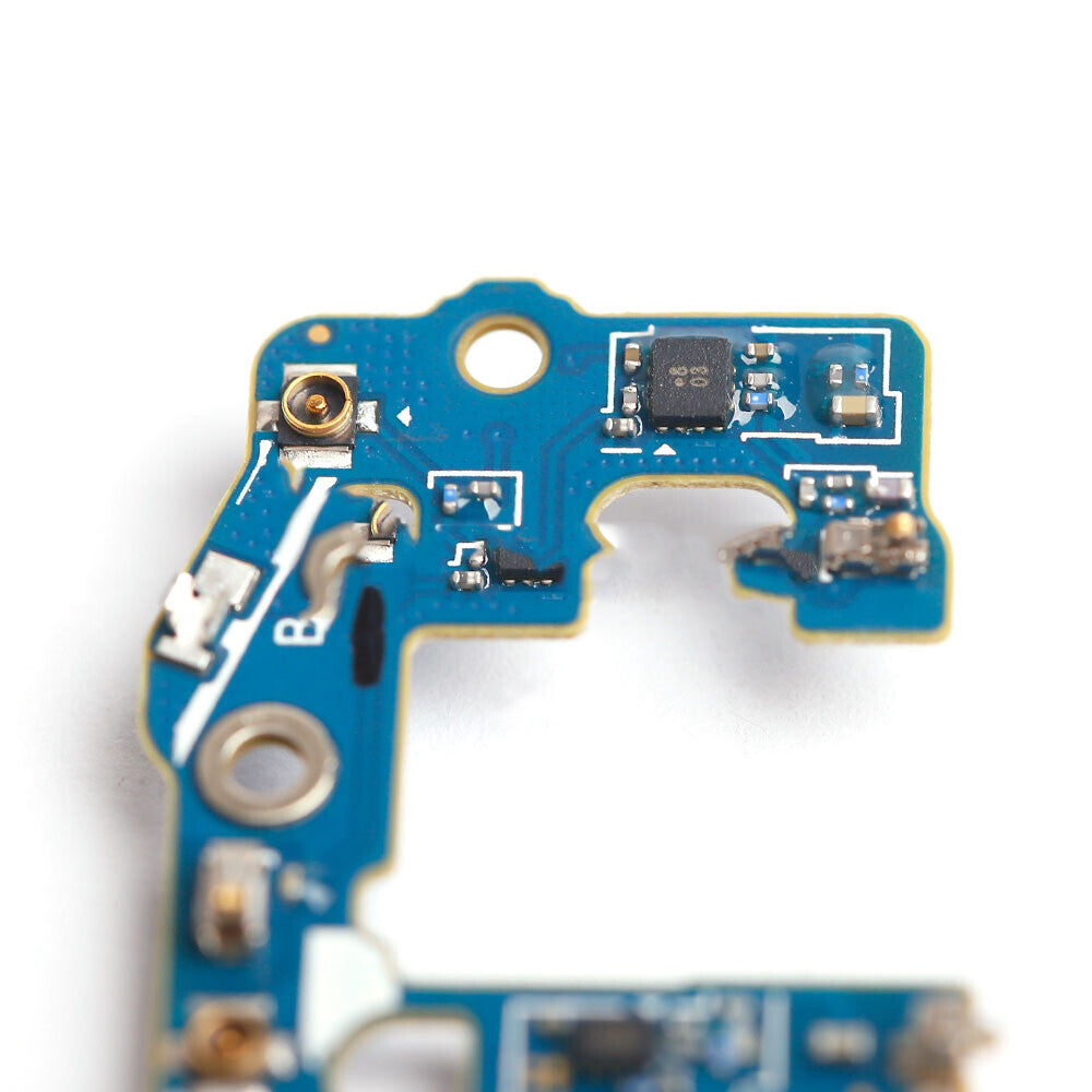 Close-up view of a blue printed circuit board with various electronic components and pathways. The board has a cutout, several connection points, and features an OG pulled Charging Port Flex Cable for a Samsung Galaxy S9 (G960U).