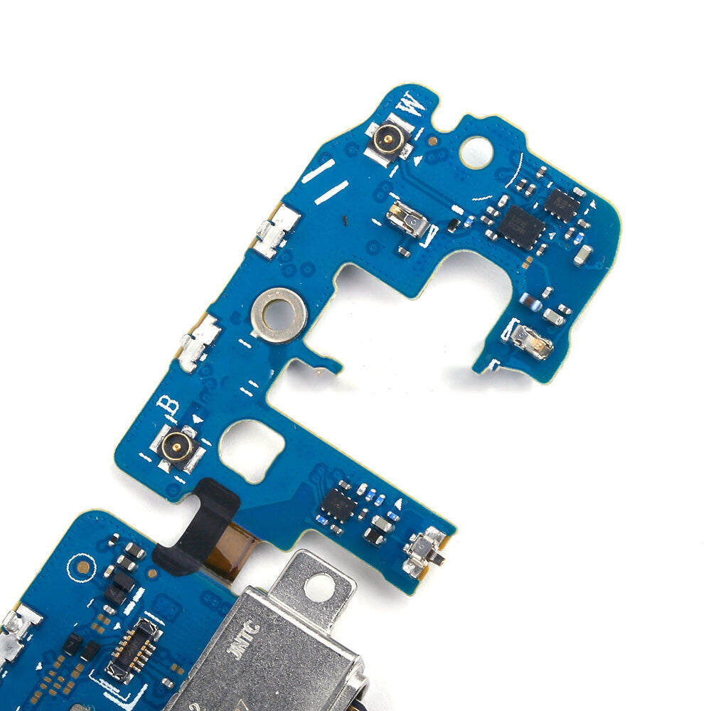 Close-up of a blue circuit board with various electronic components and connections, featuring an OG Charging Port Flex Cable for the Samsung Galaxy S9 Plus.