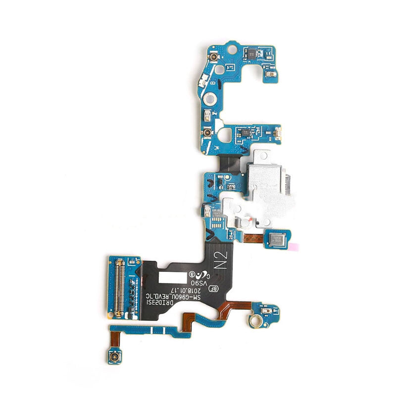 A close-up image of a blue and black circuit board with an intricate arrangement of electronic components and connectors, including an OEM pulled OG Charging Port Flex Cable for the Samsung Galaxy S9 (G960U), against a white background.