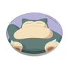 Illustration of a relaxed Snorlax Pokémon laying down inside a circular frame, compatible with wireless charging and featuring swappable PopSockets PopGrip Licensed - Snorlax Knocked.