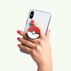 Hand holding a smartphone with a Pokémon-themed case, equipped with a PopSockets PopGrip Licensed - Pokeball for easy wireless charging.