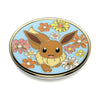 Round pin featuring an illustrated Eevee surrounded by colorful flowers against a sky-blue background, compatible with swappable PopTops for easy wireless charging.