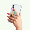 A hand with pink nail polish holding a smartphone with a patterned PopSockets PopGrip Licensed - Pokemon Multi, featuring swappable PopTops.