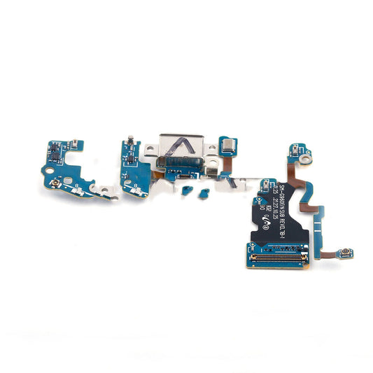 A dismantled electronics circuit board with various components, including a USB port, connectors, and chips, alongside an OEM-quality Charging Port Board for Samsung Galaxy S9 G960F by OG, displayed on a white background.