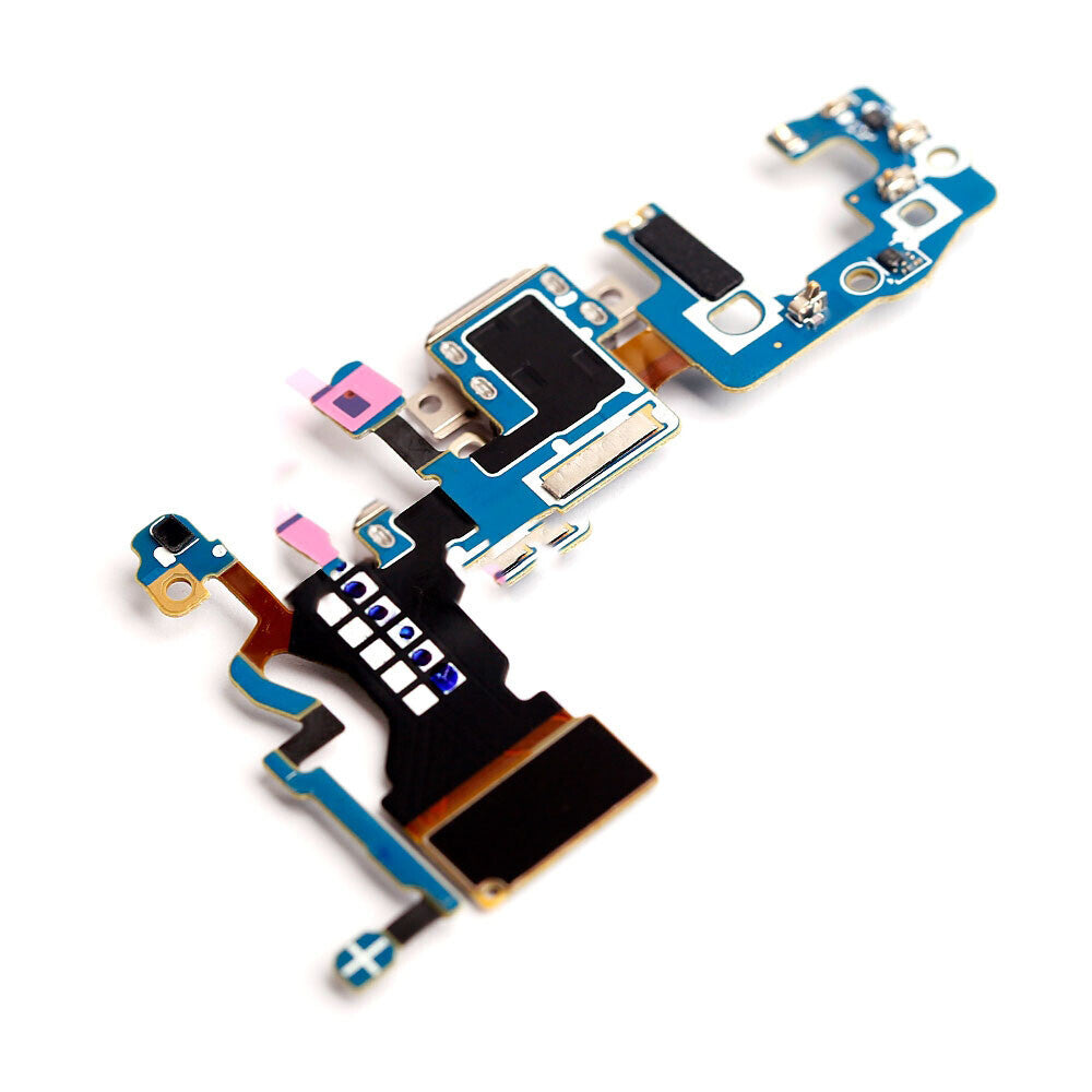 Close-up view of an electronic circuit board with various components, including blue and black sections, arranged on a white background. This board features the OG Charging Port Flex Cable for Samsung Galaxy S9 (G960U).